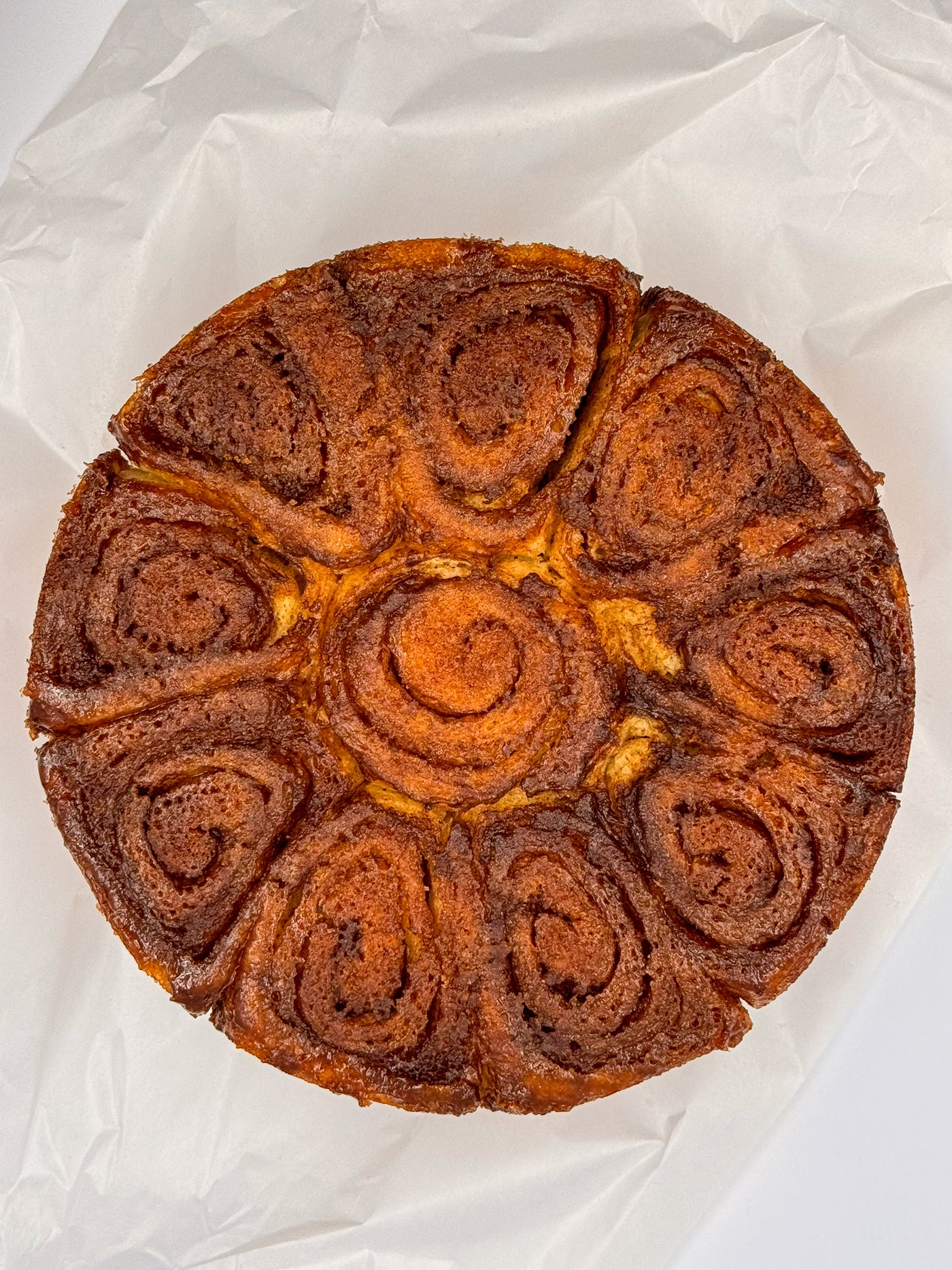 Cinnamon Scrolls by Loafology Bakery & Café—round cakes with visible spiral swirls, served on white parchment paper.