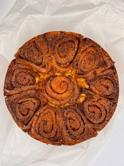 Cinnamon Scrolls by Loafology Bakery & Café—round cakes with visible spiral swirls, served on white parchment paper.